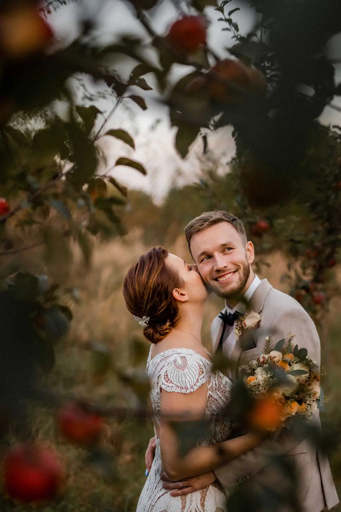 groom and bride in an apple orchard